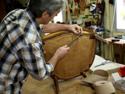 A man upholstering a chair